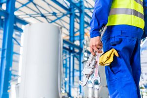 Industrial worker in factory with tools going to machine mainten