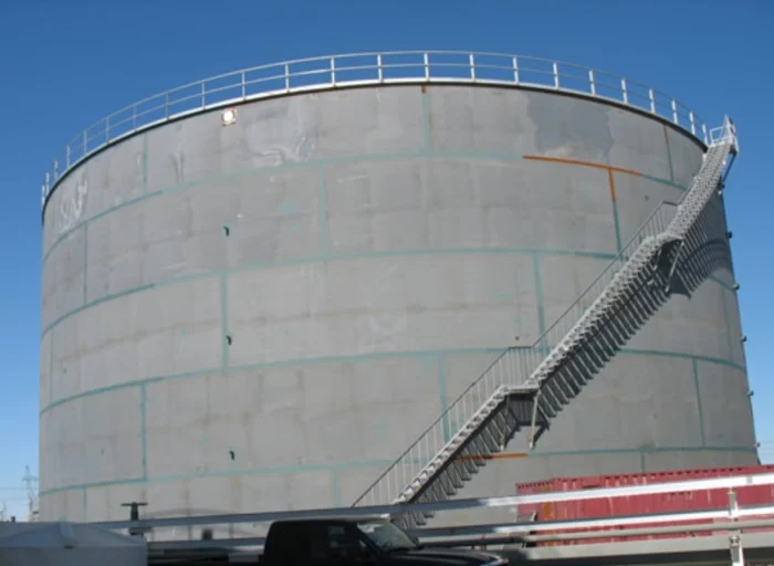 Tall steel storage vessel with access stairway